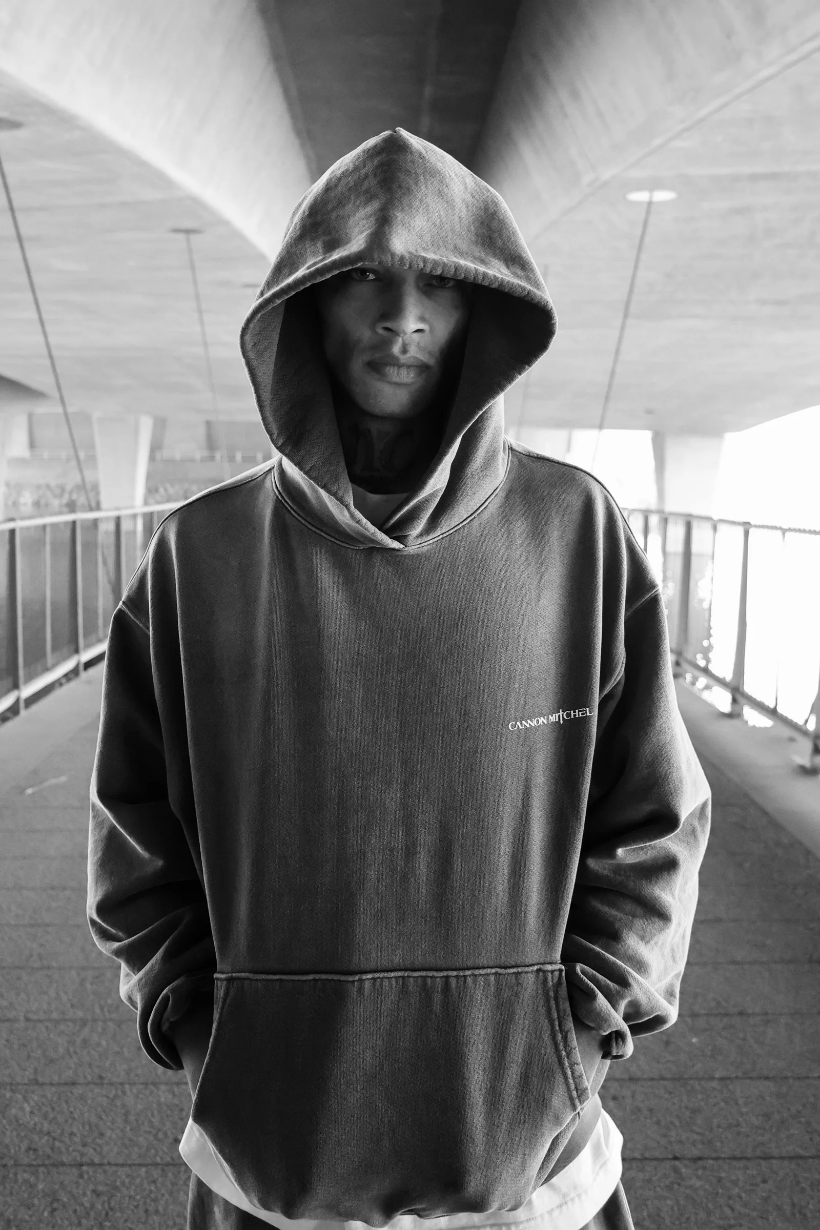 Black-and-white parking structure portrait in a Cannon Mitchel hoodie.