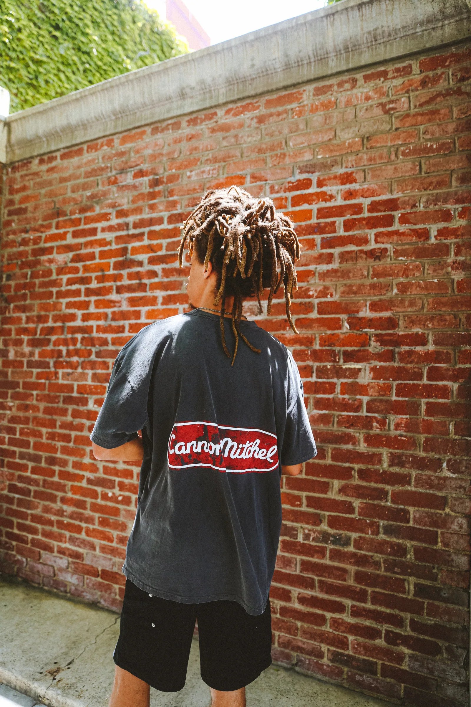 Cannon Mitchel back graphic shown in front of a brick wall.