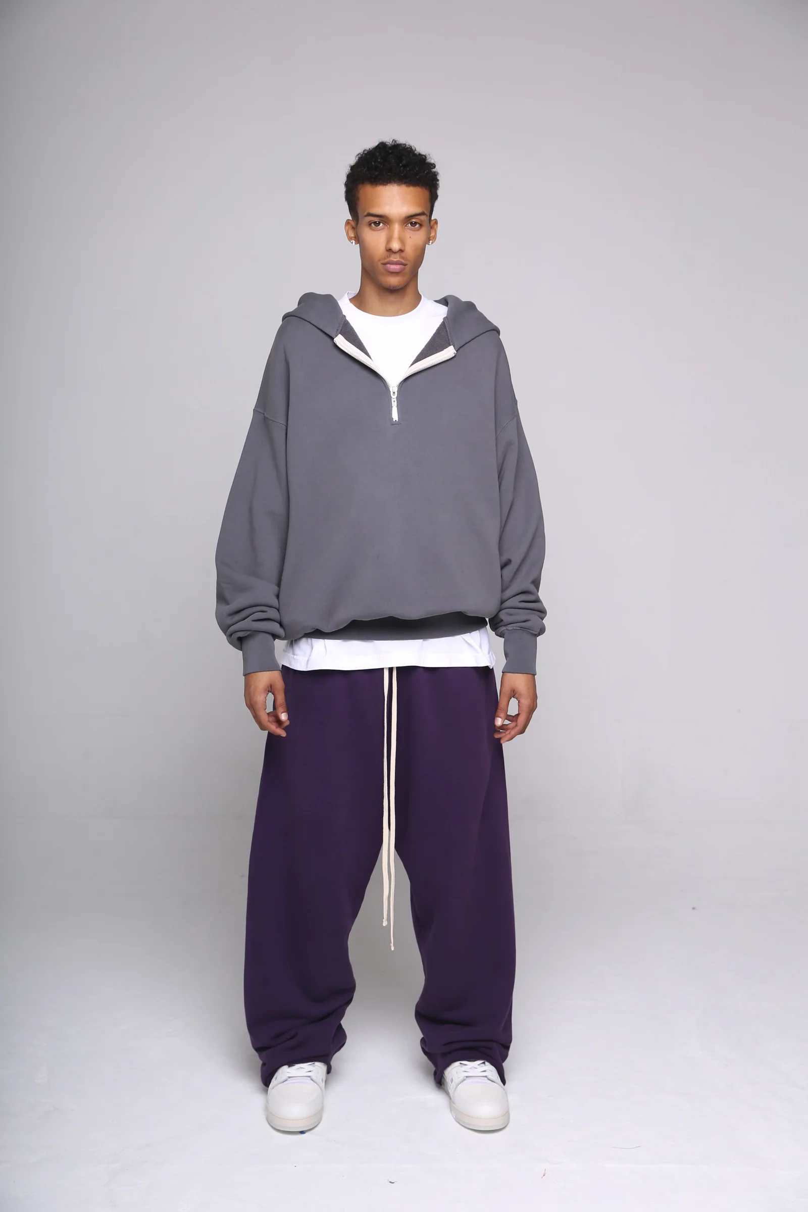 Full studio portrait of a model in a gray Cannon Mitchel zip hoodie.