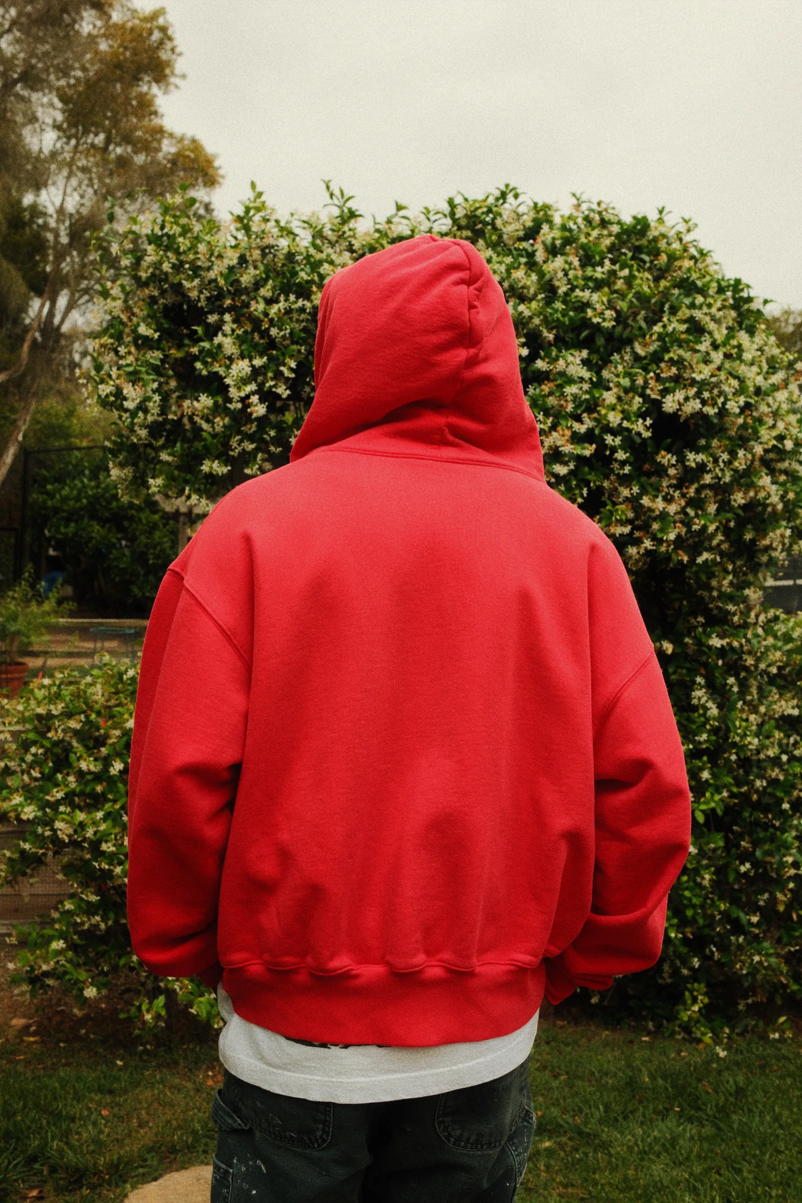 Back view of the red Cannon Mitchel hoodie in the garden.