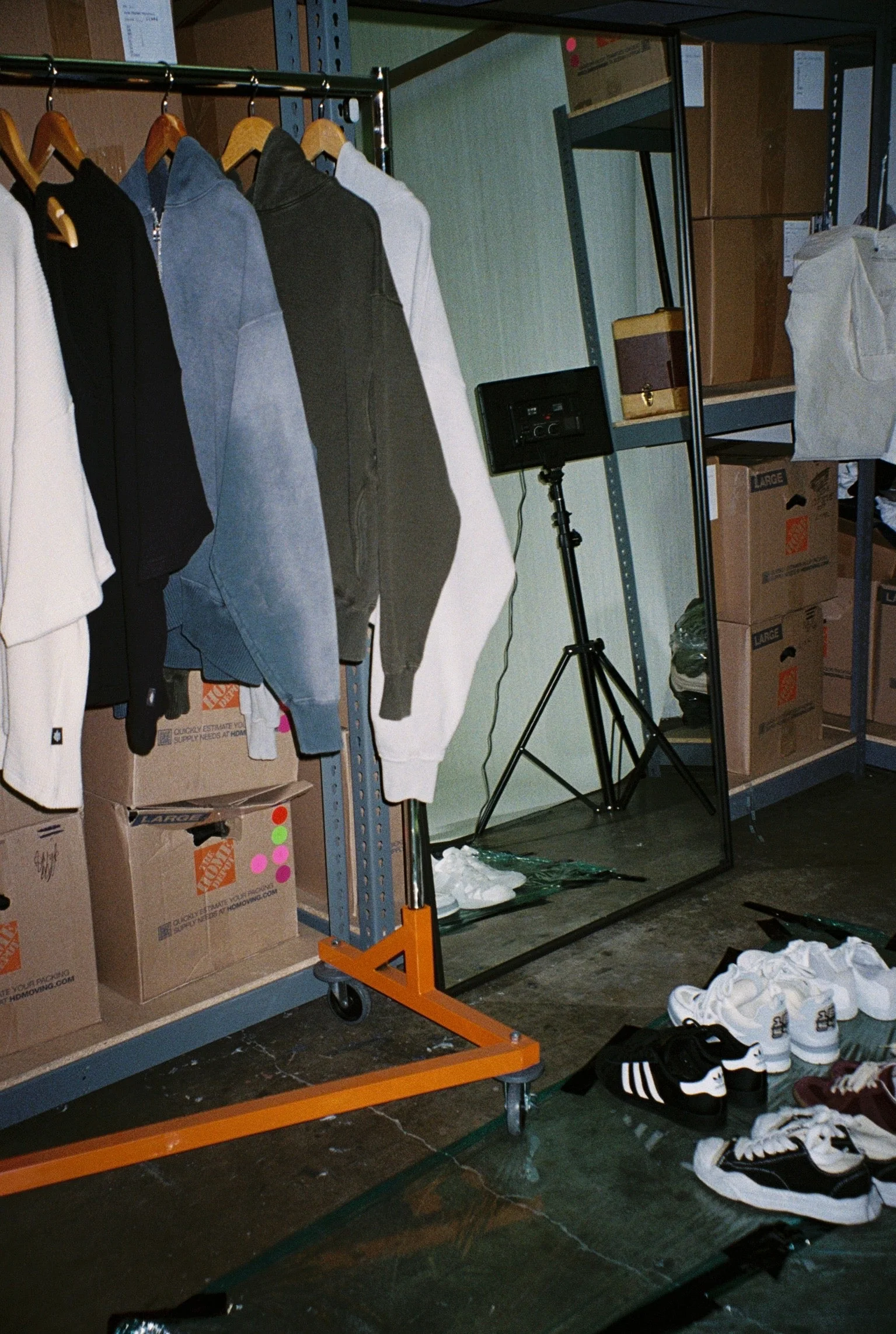 Behind-the-scenes SS26 studio rack with garments and production setup.
