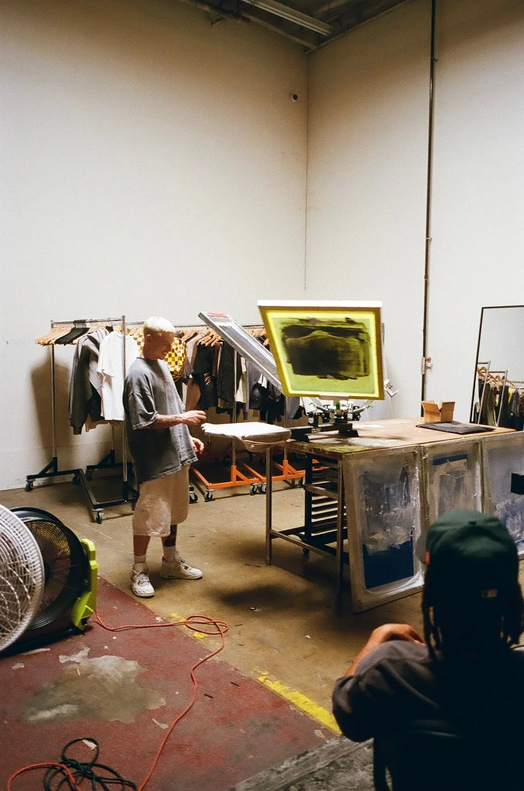 SS26 studio workspace with garment racks, lighting, and production equipment.