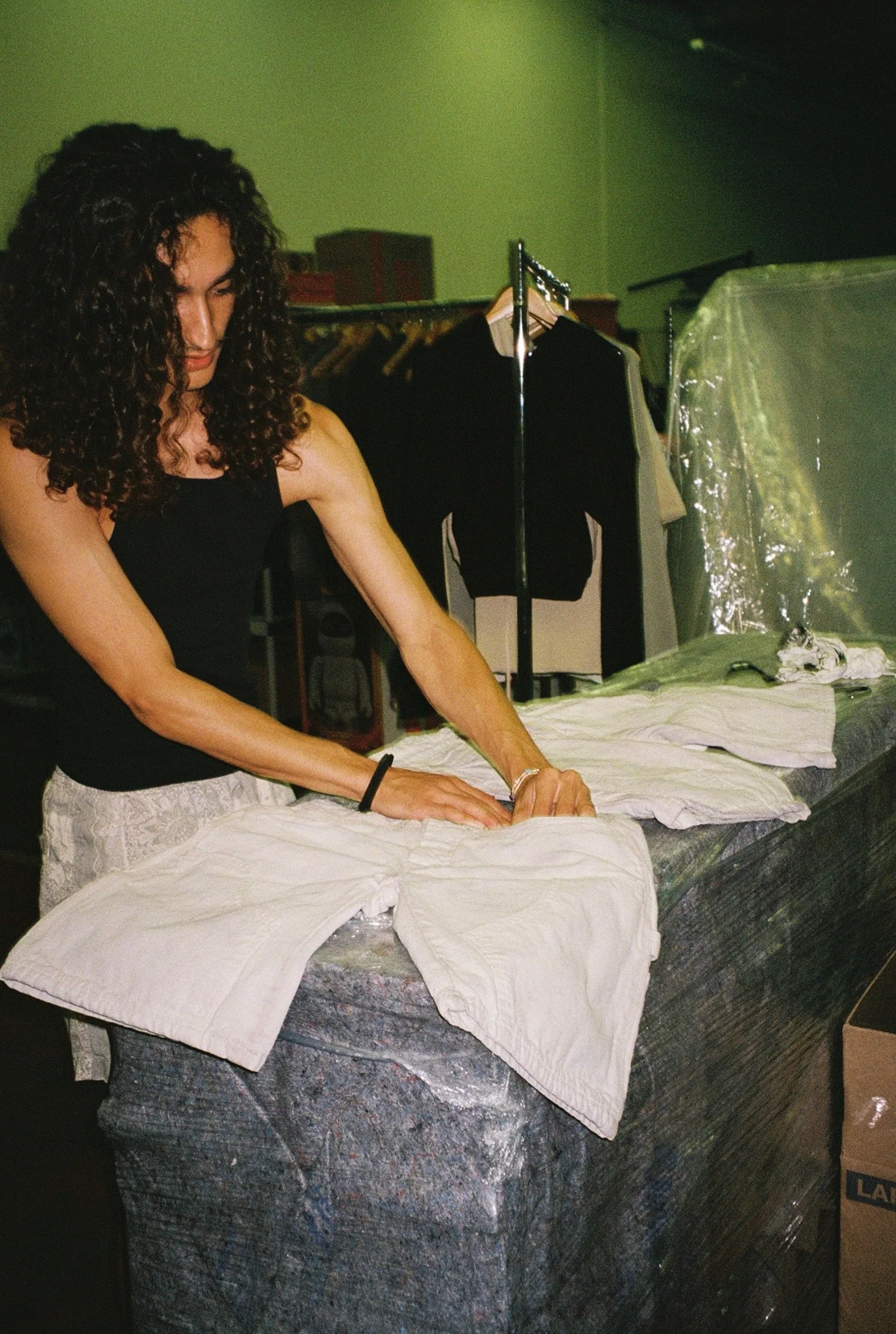 Behind-the-scenes SS26 garment handling during production.